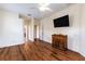 This primary bedroom features wood floors, ample space, and a mounted TV for relaxation at 27127 Stoney Brook Dr, Leesburg, FL 34748