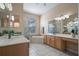 Well-lit bathroom with double sinks, a bathtub, a glass-enclosed shower, and a large mirror reflecting the space at 2732 Aloma Oaks Dr, Oviedo, FL 32765