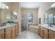 Bathroom featuring double vanities, a glass shower, and a soaking tub at 2732 Aloma Oaks Dr, Oviedo, FL 32765