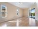 Spacious bedroom featuring hardwood floors, two windows, and sliding glass doors leading to the outdoor patio area at 2732 Aloma Oaks Dr, Oviedo, FL 32765