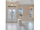 Bright foyer with decorative glass doors, chandelier, and neutral tile flooring creates a grand entrance at 2732 Aloma Oaks Dr, Oviedo, FL 32765