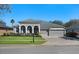 Charming single-story home with a well-manicured lawn, gray color palette, and a three car garage at 2732 Aloma Oaks Dr, Oviedo, FL 32765