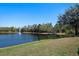 Scenic pond with a fountain surrounded by lush greenery on a sunny day at 2732 Aloma Oaks Dr, Oviedo, FL 32765