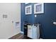 Well-organized laundry room with a modern laundry hamper and blue accent wall at 2984 Moulin Rd, Davenport, FL 33837