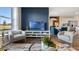 Modern living room with stylish furnishings, wood floors, blue accent wall, and seamless flow to the dining area at 2984 Moulin Rd, Davenport, FL 33837