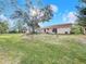 Expansive backyard with lush lawn and mature shade trees on a sunny day at 310 Sunvista Ct, Sanford, FL 32773