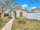 Inviting home with manicured lawn, featuring arched windows, green door, and a quaint walkway at 310 Sunvista Ct, Sanford, FL 32773