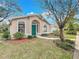 Charming home featuring a manicured front yard with lush landscaping, a green door and arched windows at 310 Sunvista Ct, Sanford, FL 32773