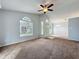 Cozy living room with ceiling fan, carpeted floors, and arched windows creating a welcoming space at 310 Sunvista Ct, Sanford, FL 32773