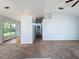 Open-concept living room featuring neutral walls, carpet flooring, and a large window for natural light at 310 Sunvista Ct, Sanford, FL 32773