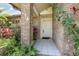 Welcoming front entrance with brick pillars, a white front door, and lush landscaping at 314 Silk Oak Dr, Kissimmee, FL 34743