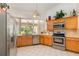 Modern kitchen with stainless steel appliances, light wood cabinets, and a bright window at 314 Silk Oak Dr, Kissimmee, FL 34743