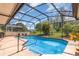 Outdoor pool area is enclosed with a black metal screen and features lush landscaping at 314 Silk Oak Dr, Kissimmee, FL 34743