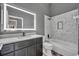 This renovated bathroom features an illuminated mirror, modern finishes, and a tub with a shower at 3664 Sickle St, Orlando, FL 32812