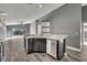 Kitchen showcasing stainless steel appliances, dark cabinets, and wood-look flooring that opens to living area at 3664 Sickle St, Orlando, FL 32812