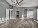 Spacious main bedroom with wood-look tile flooring, gray walls, and open doorway to the en-suite bathroom at 3664 Sickle St, Orlando, FL 32812