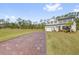 Expansive property showcasing the house's brick driveway, sizable lawn and wooded backdrop, promoting a serene setting at 3916 Clipstone Pl, Sanford, FL 32773