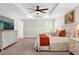 Well-lit main bedroom with a tray ceiling, ceiling fan, dresser, and serene ambiance at 3916 Clipstone Pl, Sanford, FL 32773