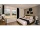 Well-lit bedroom featuring large windows, neutral tones, soft carpeting, and elegant bedside lighting at 5169 Forget Me Not Ave, Lake Hamilton, FL 33851