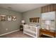 Charming Bedroom with soft green walls, wooden accents, decorative artwork, and a cozy crib at 5169 Forget Me Not Ave, Lake Hamilton, FL 33851