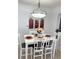 Stylish dining room featuring a modern light fixture and a well-set white table for six at 547 Madina Cir, Davenport, FL 33837