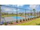 Outdoor pickleball court with blue and orange zones is enclosed by a chain-link fence, inviting recreational activities at 6068 Peaceful Pkwy, Clermont, FL 34714