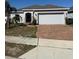 Charming single-story home with a well-manicured lawn and brick-paved driveway at 622 Samuel Pl, Davenport, FL 33837