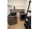 Laundry room featuring modern washer and dryer with tile flooring, and functional shelving at 622 Samuel Pl, Davenport, FL 33837