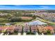 Aerial view of a suburban neighborhood with a pond, trees, and neatly arranged houses at 7587 Oakmoss Loop, Davenport, FL 33837