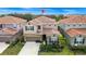 Aerial view of a two-story home with a tile roof, landscaped yard and proximity to neighboring houses at 7587 Oakmoss Loop, Davenport, FL 33837