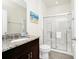 Bathroom featuring a granite vanity, modern fixtures, and a glass-enclosed shower at 7587 Oakmoss Loop, Davenport, FL 33837