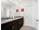 Bathroom features granite countertop with double sinks, a large mirror, and tiled floor at 7587 Oakmoss Loop, Davenport, FL 33837