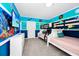 Ocean-themed bedroom with bunk beds, colorful decor, and a large flat-screen TV at 7587 Oakmoss Loop, Davenport, FL 33837