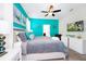 Brightly colored bedroom featuring a ceiling fan, neutral carpet and a large window for lots of natural light at 7587 Oakmoss Loop, Davenport, FL 33837