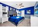 Comfortable bedroom with a large king bed, blue accent wall, and ample natural light at 7587 Oakmoss Loop, Davenport, FL 33837