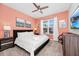 Cozy bedroom featuring a ceiling fan, neutral carpet and a large window for lots of natural light at 7587 Oakmoss Loop, Davenport, FL 33837