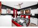 Bright bedroom with a red frame bed, black and white bedding, and stylish decor at 7587 Oakmoss Loop, Davenport, FL 33837