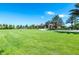 A beautiful community clubhouse surrounded by lush green grass and swaying palm trees against a blue sky at 7587 Oakmoss Loop, Davenport, FL 33837