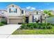 Charming two-story home featuring a well-manicured lawn and a two-car garage at 7587 Oakmoss Loop, Davenport, FL 33837