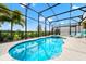 Screened in pool and patio with blue tile and lounge chairs create a relaxing backyard oasis at 7587 Oakmoss Loop, Davenport, FL 33837