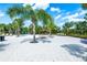 Expansive pool deck area with multiple lounge chairs and umbrellas, surrounded by tropical landscaping and palm trees at 7587 Oakmoss Loop, Davenport, FL 33837