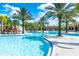 Expansive pool area with swaying palms, offering a tropical oasis for swimming and lounging in the sun at 7587 Oakmoss Loop, Davenport, FL 33837