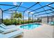 Relaxing screened-in pool area with lounge chairs, a hot tub, and lush greenery at 7587 Oakmoss Loop, Davenport, FL 33837