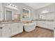 Luxurious bathroom featuring double vanities, a soaking tub, and granite countertops at 8330 Vivaro Isle Way, Windermere, FL 34786