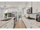 Open kitchen featuring stainless steel appliances, quartz counters, and white cabinetry at 8330 Vivaro Isle Way, Windermere, FL 34786