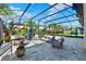 Covered patio with a seating area, stylish decor, tropical greenery, and a screened enclosure at 8330 Vivaro Isle Way, Windermere, FL 34786