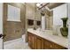 Bathroom with a vanity, cream countertop, framed mirror, towels, white toilet, and a window with shutters at 8814 Southern Breeze Dr, Orlando, FL 32836