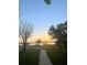 A lovely view of the sunrise over the water with the dock and gazebo in the distance at 8814 Southern Breeze Dr, Orlando, FL 32836