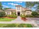 Stunning Mediterranean-style home featuring a red tile roof, lush landscaping, and a welcoming brick walkway at 8814 Southern Breeze Dr, Orlando, FL 32836