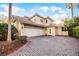 Elegant two-story house featuring a tile roof, three-car garage, and a lush, landscaped driveway at 8814 Southern Breeze Dr, Orlando, FL 32836